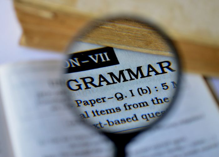 Magnifying glass zooming in on the word "Grammar"